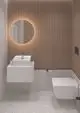 Waschtisch mit einer modernen, weißen Armatur von Ideal Standard, eingebaut in eine Wandverkleidung aus Holzlamellen, ergänzt durch einen ovalen Spiegel und ein hängendes WC.